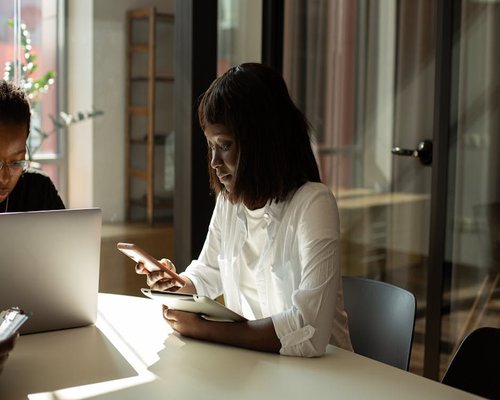 Person holding a smartphone at eye level while sitting